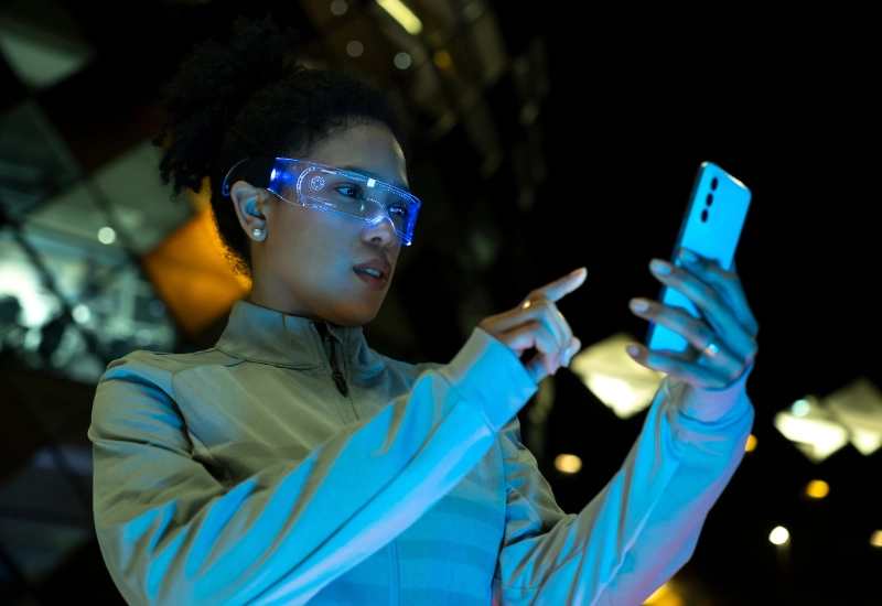 Woman wears augmented reality glasses while using a smart phone.