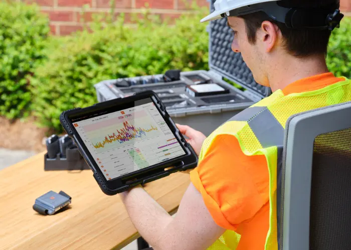 safety leader holds and reviews biometric data on SlateSafety's solution with a tablet.